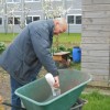 Herman zet de boeidelen van de huurhokjes in de olie.